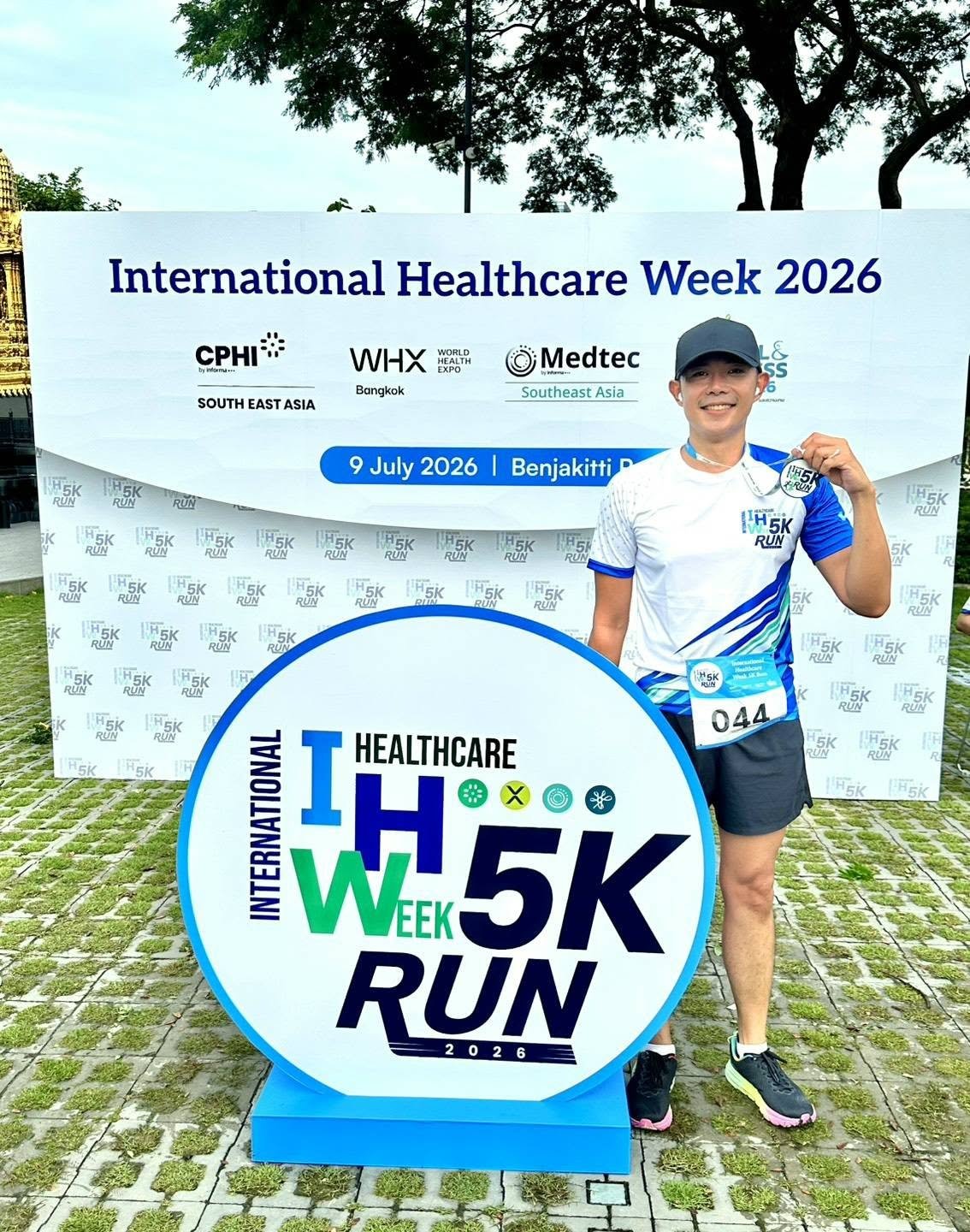 นักวิ่งทีม BioCotton ถือเหรียญรางวัลหน้าป้ายงาน International Health Week 5K Run 2026